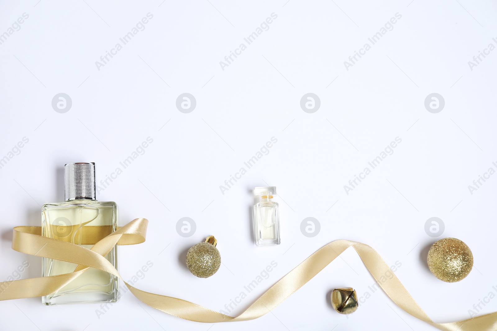 Photo of Christmas composition with perfume bottles on white background, flat lay. Space for text