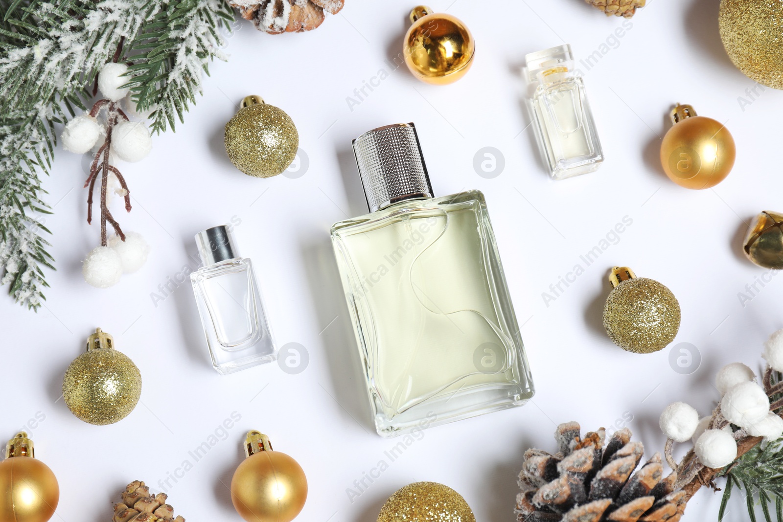 Photo of Christmas composition with perfume bottles on white background, flat lay