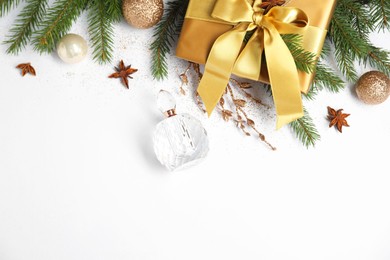 Photo of Christmas composition with perfume bottle on white background, flat lay. Space for text