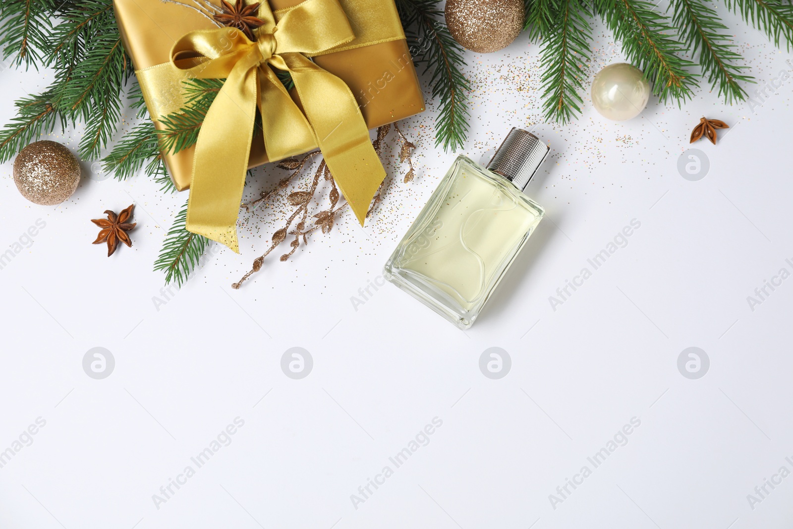 Photo of Christmas composition with perfume bottle on white background, flat lay. Space for text