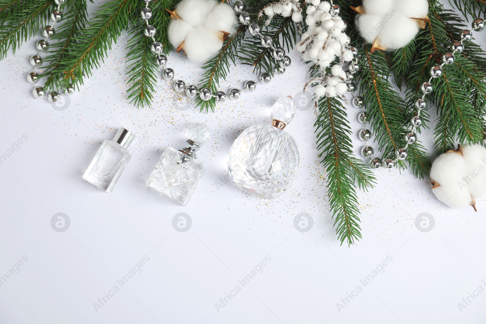 Photo of Christmas composition with perfume bottles on white background, flat lay