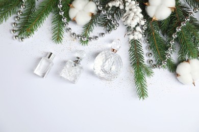 Christmas composition with perfume bottles on white background, flat lay