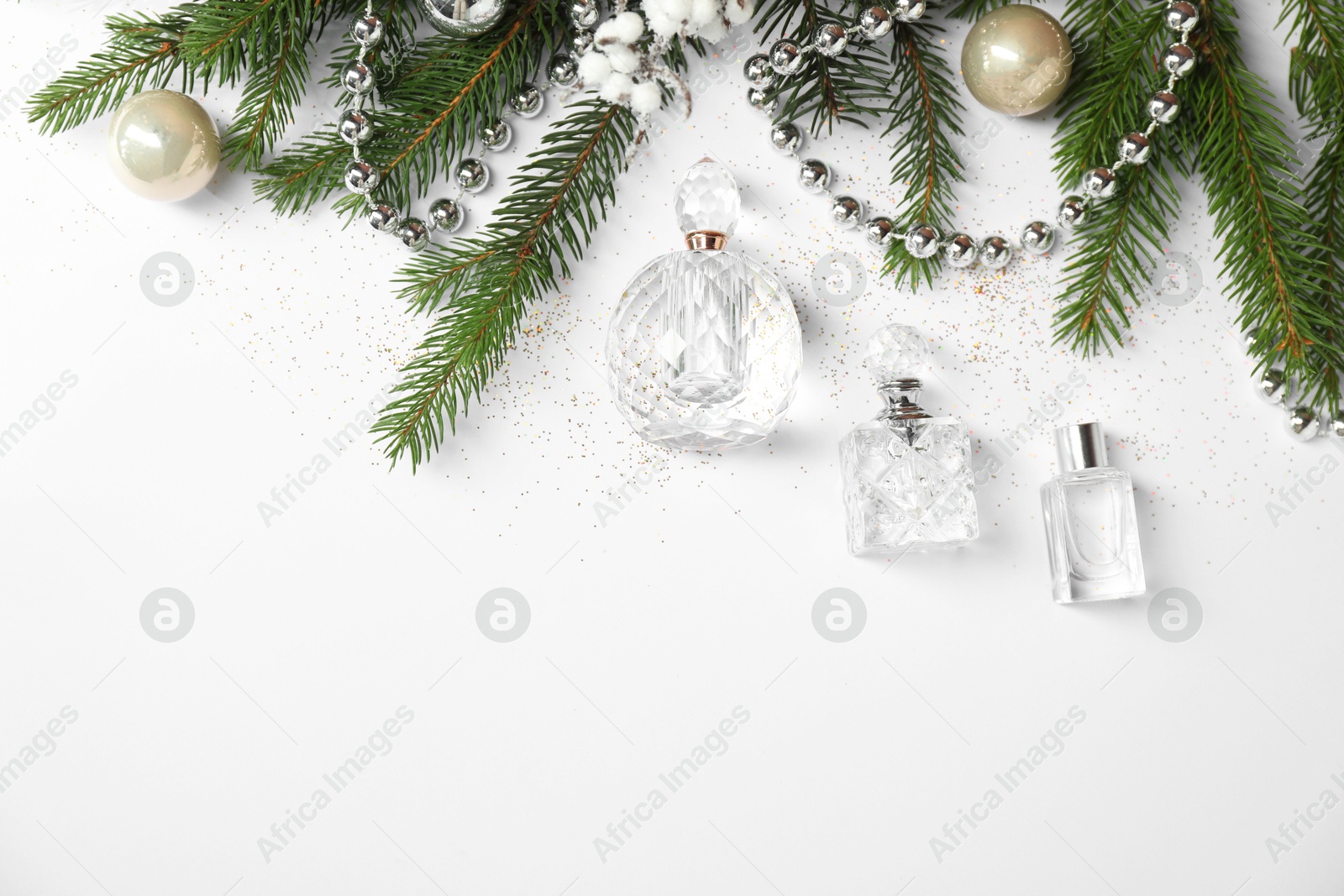 Photo of Christmas composition with perfume bottles on white background, flat lay. Space for text