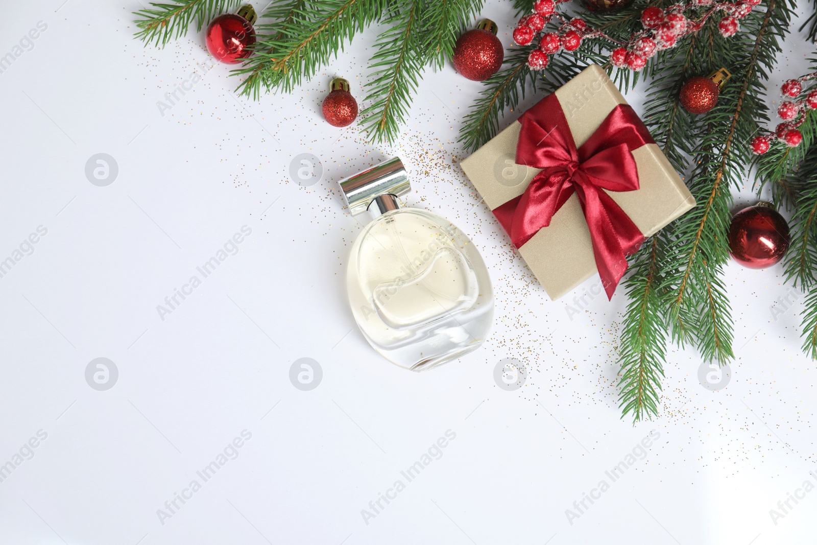 Photo of Christmas composition with perfume bottle on white background, flat lay. Space for text