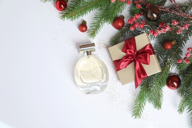 Photo of Christmas composition with perfume bottle on white background, flat lay. Space for text