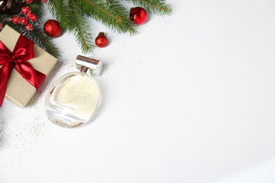 Christmas composition with perfume bottle on white background, above view. Space for text