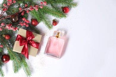 Christmas composition with perfume bottle on white background, above view. Space for text