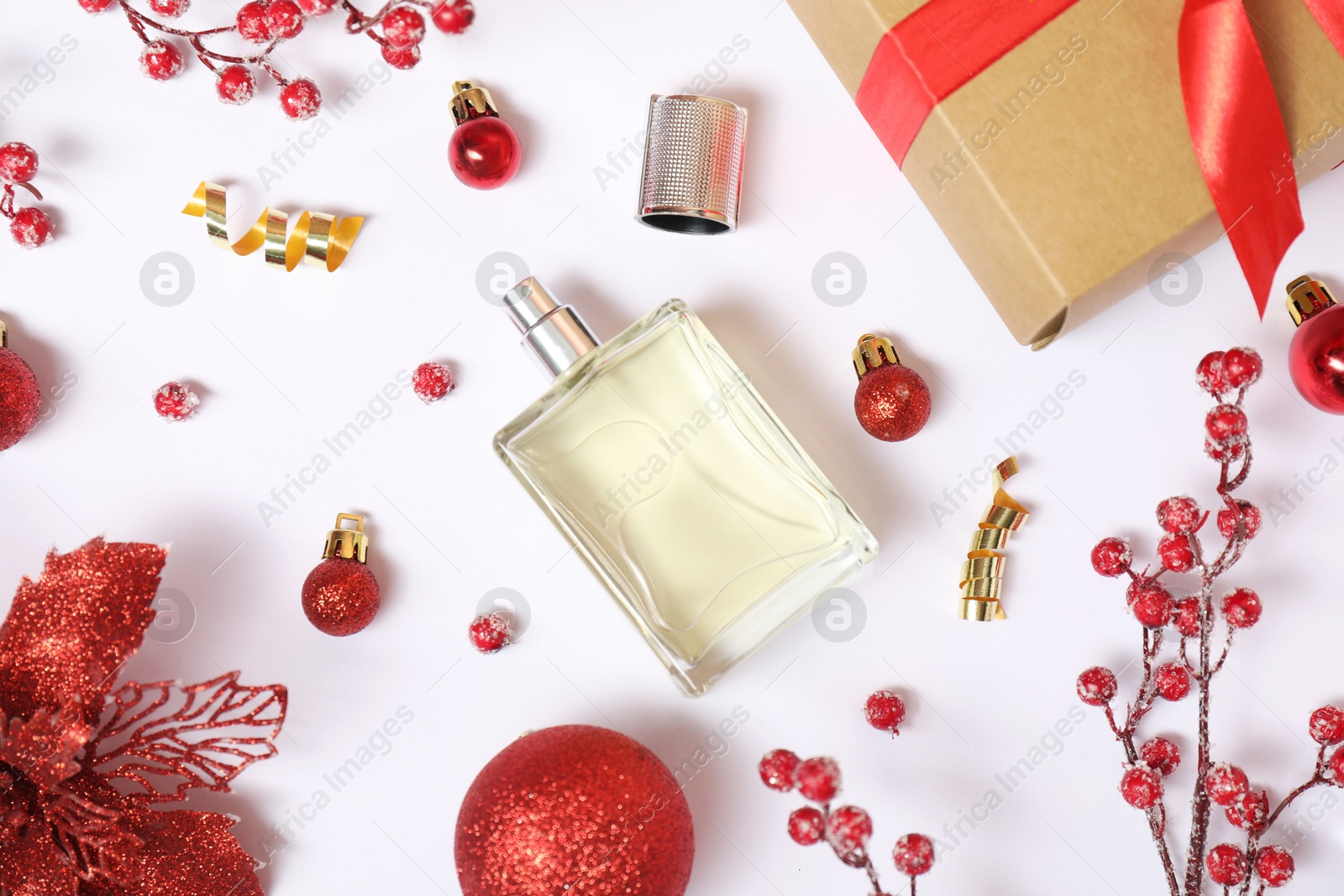 Photo of Christmas composition with perfume bottle on white background, flat lay