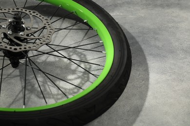 Bicycle wheel with tire on grey background, closeup