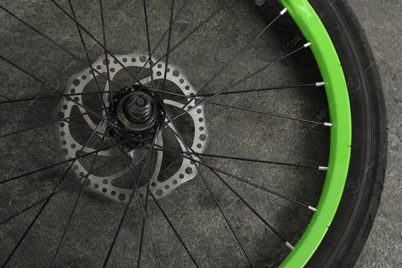 Photo of Bicycle wheel with tire on grey background, closeup