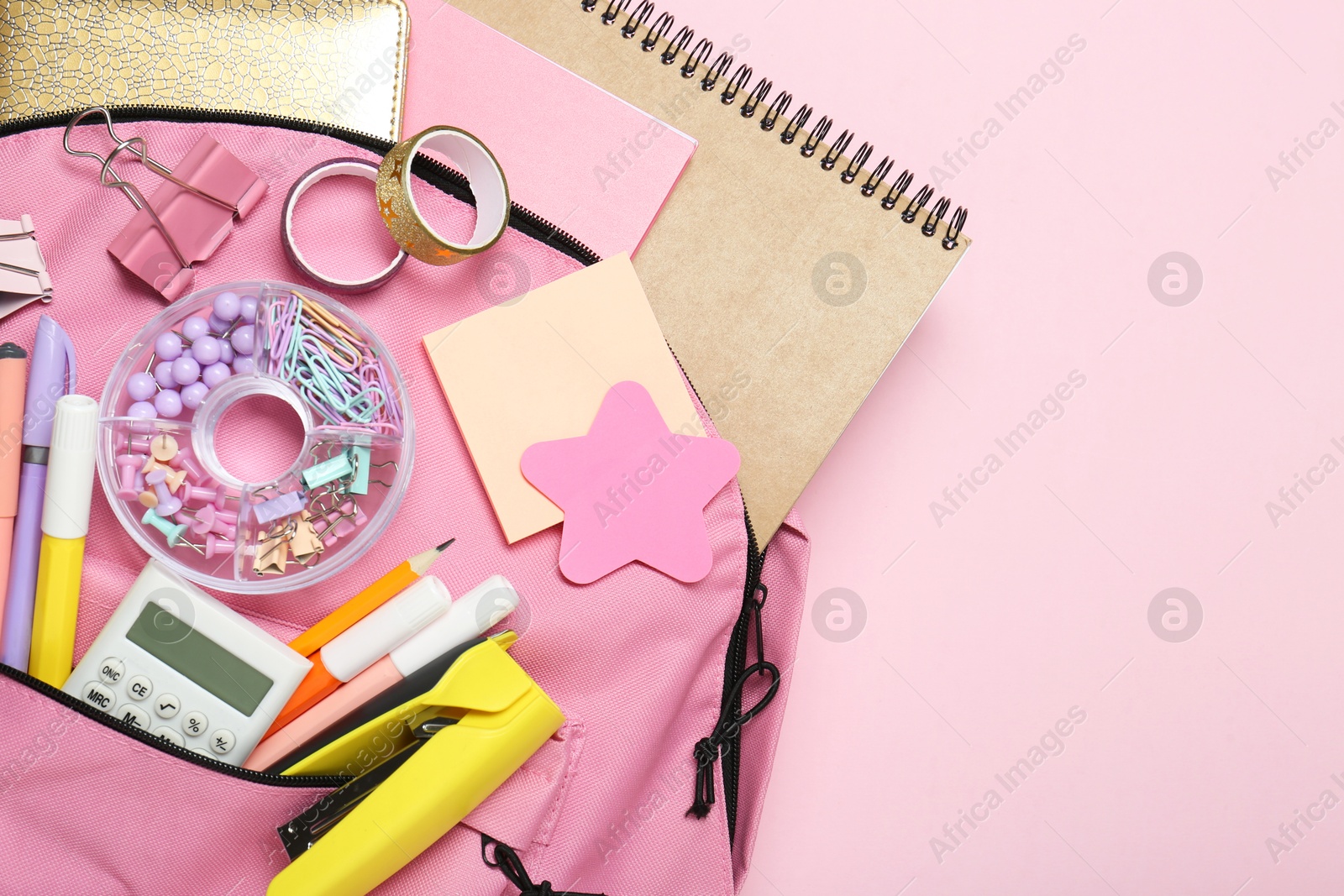 Photo of Backpack and different school stationery on pink background, top view. Space for text