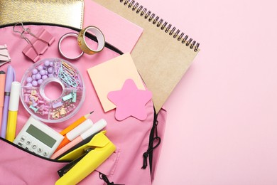 Photo of Backpack and different school stationery on pink background, top view. Space for text