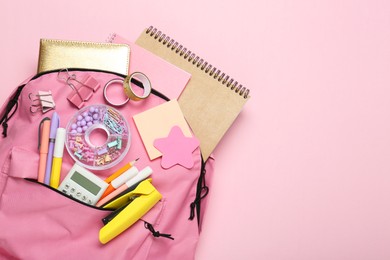 Photo of Backpack and different school stationery on pink background, top view. Space for text