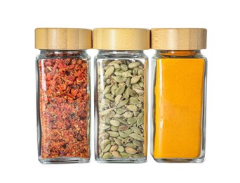 Photo of Different spices in glass jars isolated on white