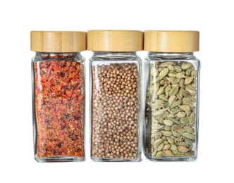 Photo of Different spices in glass jars isolated on white