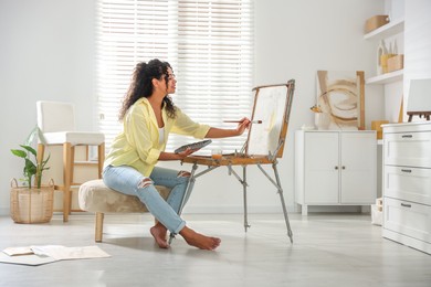 Smiling woman drawing picture in art studio