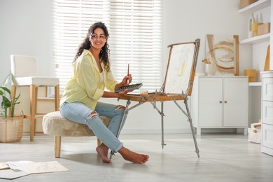 Smiling woman drawing picture in art studio