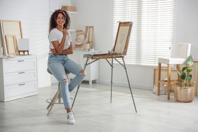 Photo of Happy woman drawing picture with pencil in studio