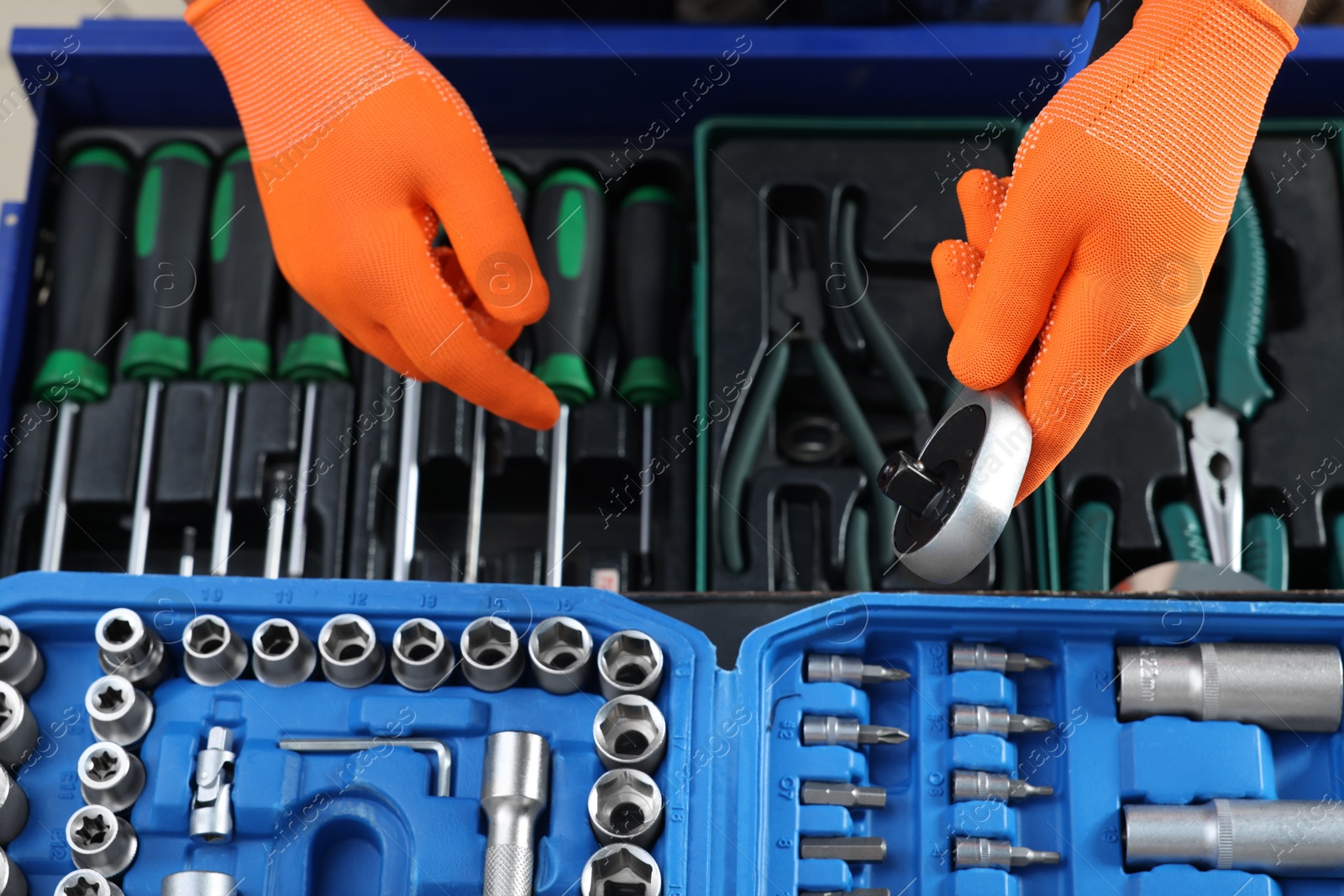 Photo of Auto mechanic with torque wrench and different tools at automobile repair shop, top view