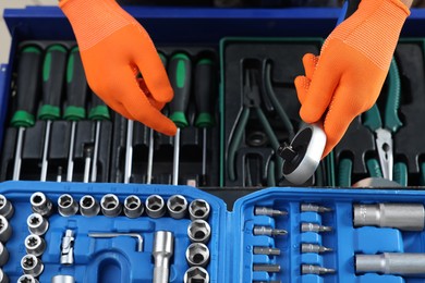 Photo of Auto mechanic with torque wrench and different tools at automobile repair shop, top view