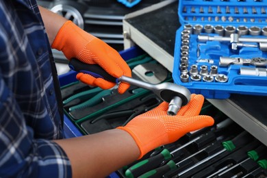 Photo of Auto mechanic with torque wrench and different tools at automobile repair shop, closeup