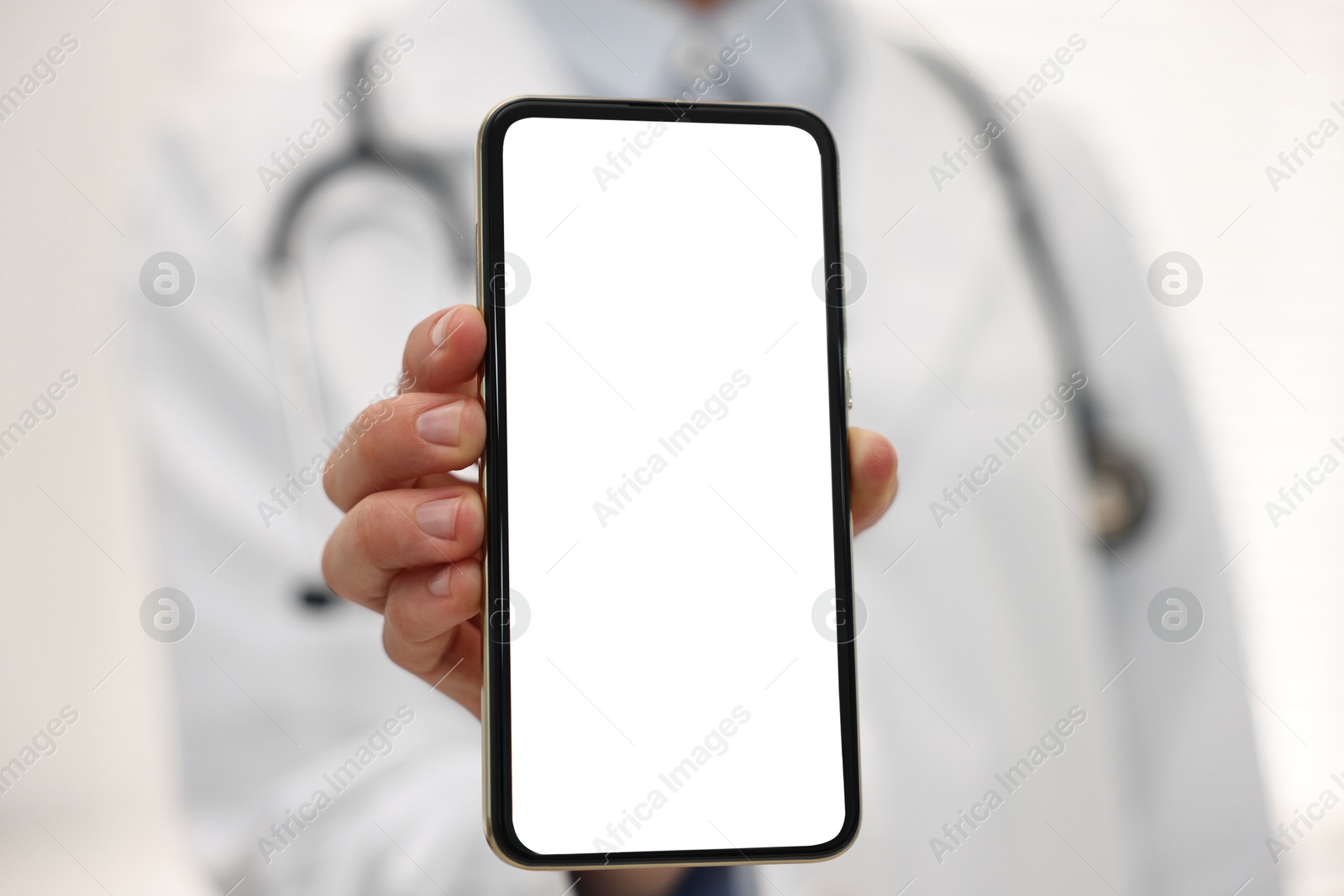 Photo of Doctor showing smartphone with blank screen in hospital, selective focus