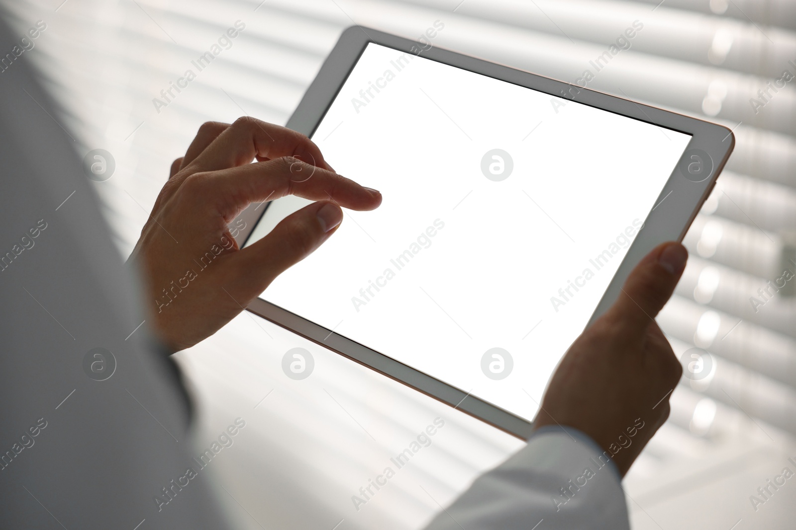 Photo of Doctor using tablet in hospital, closeup view