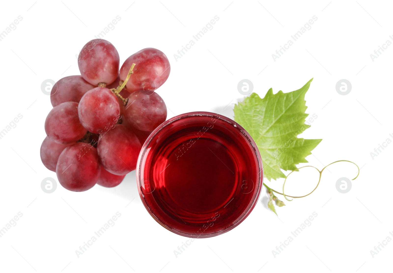 Photo of Ripe grapes and glass of tasty juice isolated on white, top view