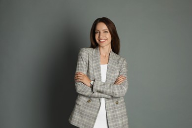 Beautiful woman in stylish jacket on grey background