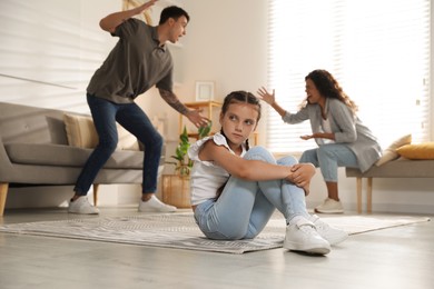 Photo of Divorce concept. Angry couple arguing at home, focus on their sad daughter