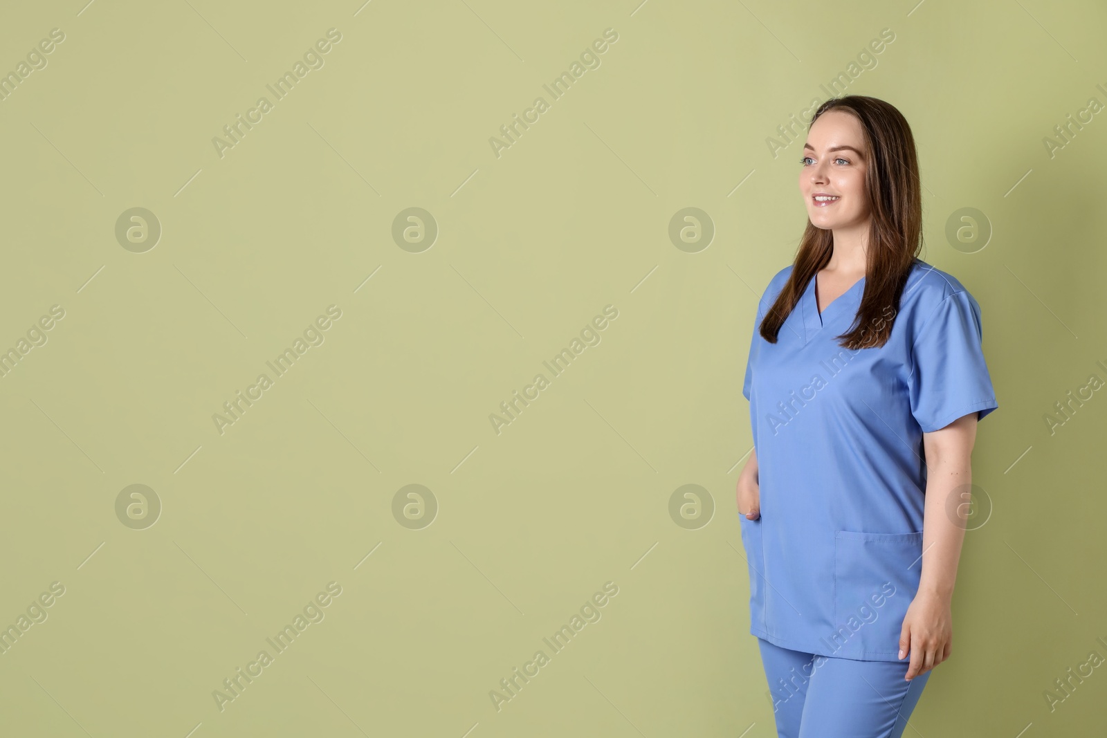 Photo of Professional nurse in uniform on pale green background. Space for text