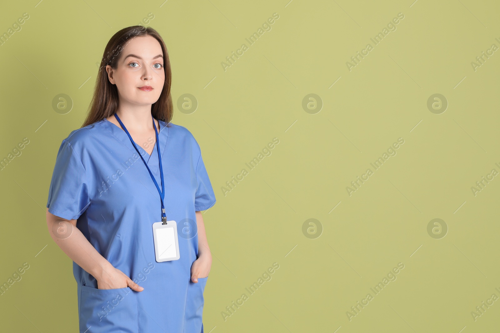 Photo of Professional nurse with badge on pale green background. Space for text