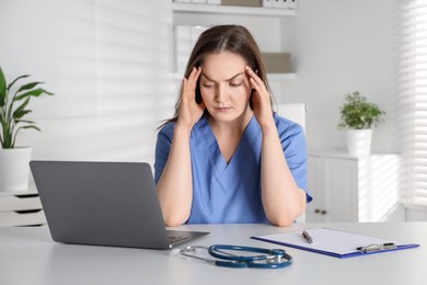 Tired nurse working at desk in hospital