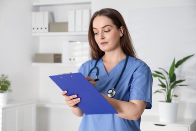 Portrait of professional nurse with clipboard in clinic