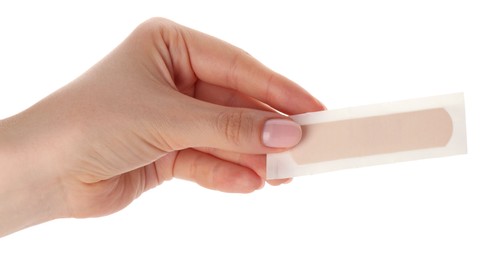 Photo of Woman holding medical adhesive bandage on white background, closeup