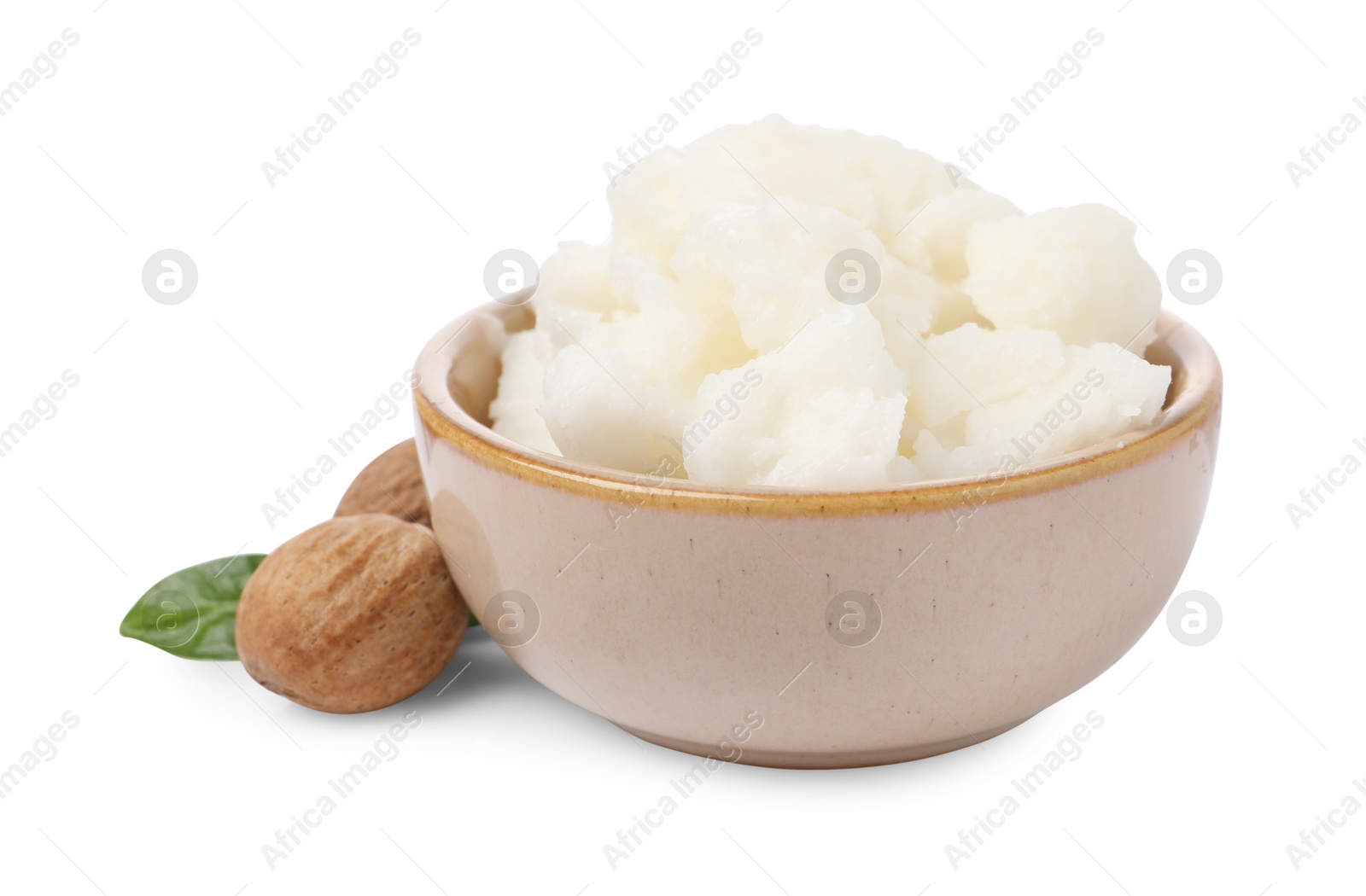 Photo of Shea butter in bowl and nuts isolated on white