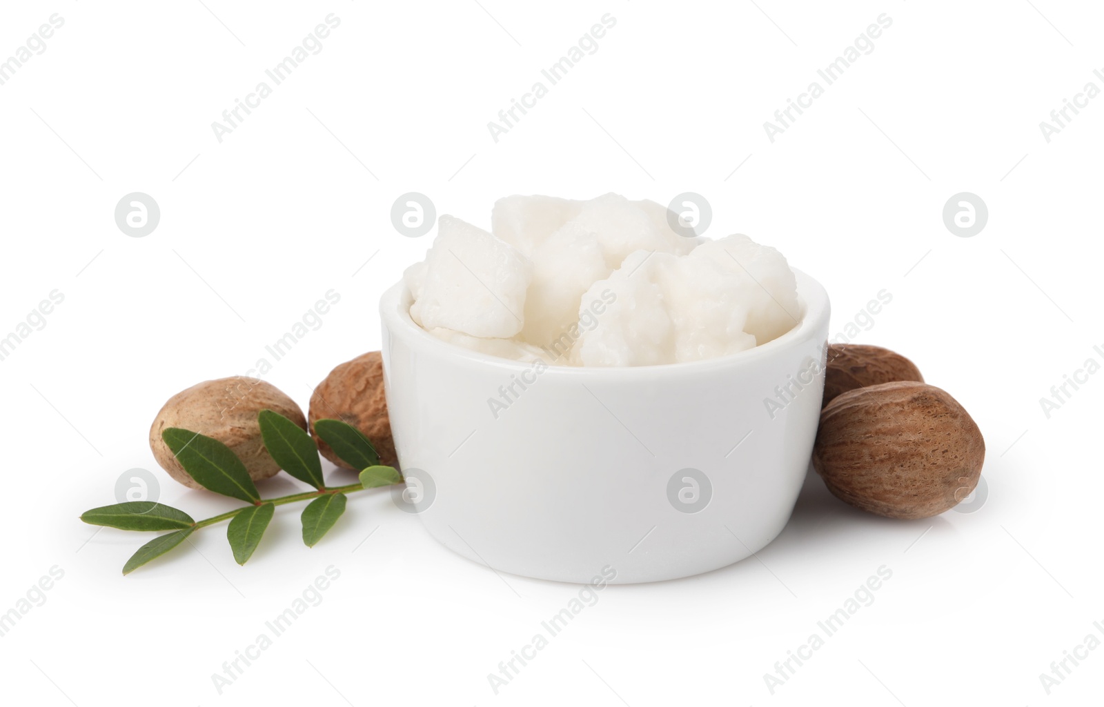 Photo of Shea butter in bowl and nuts isolated on white