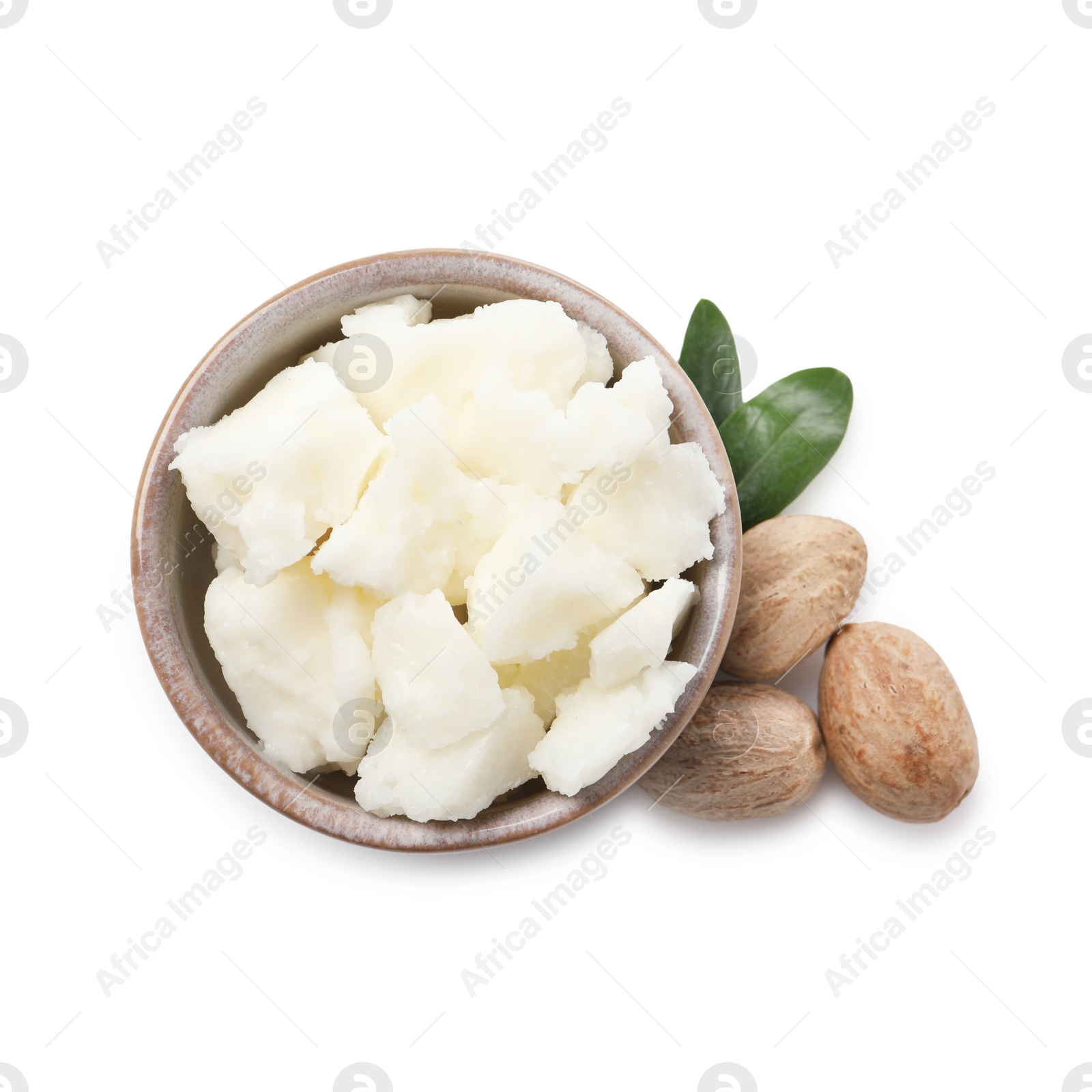 Photo of Shea butter in bowl and nuts isolated on white, top view