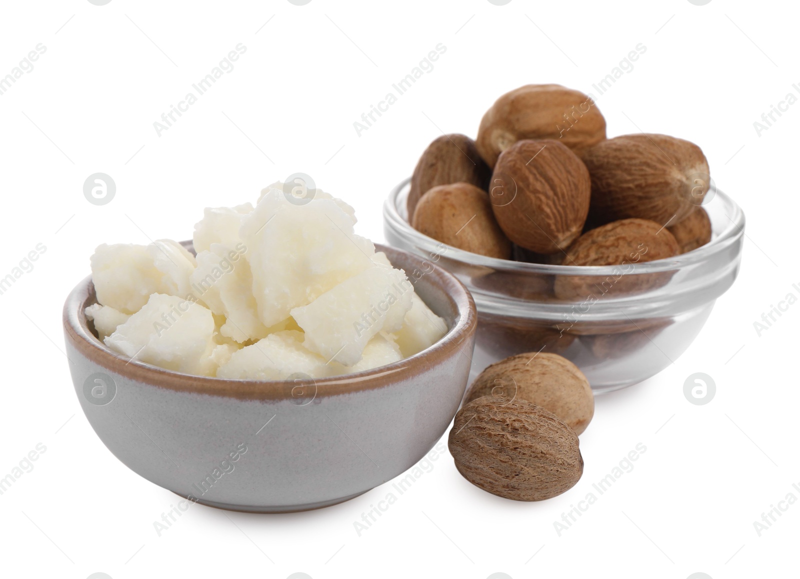 Photo of Shea butter in bowl and nuts isolated on white