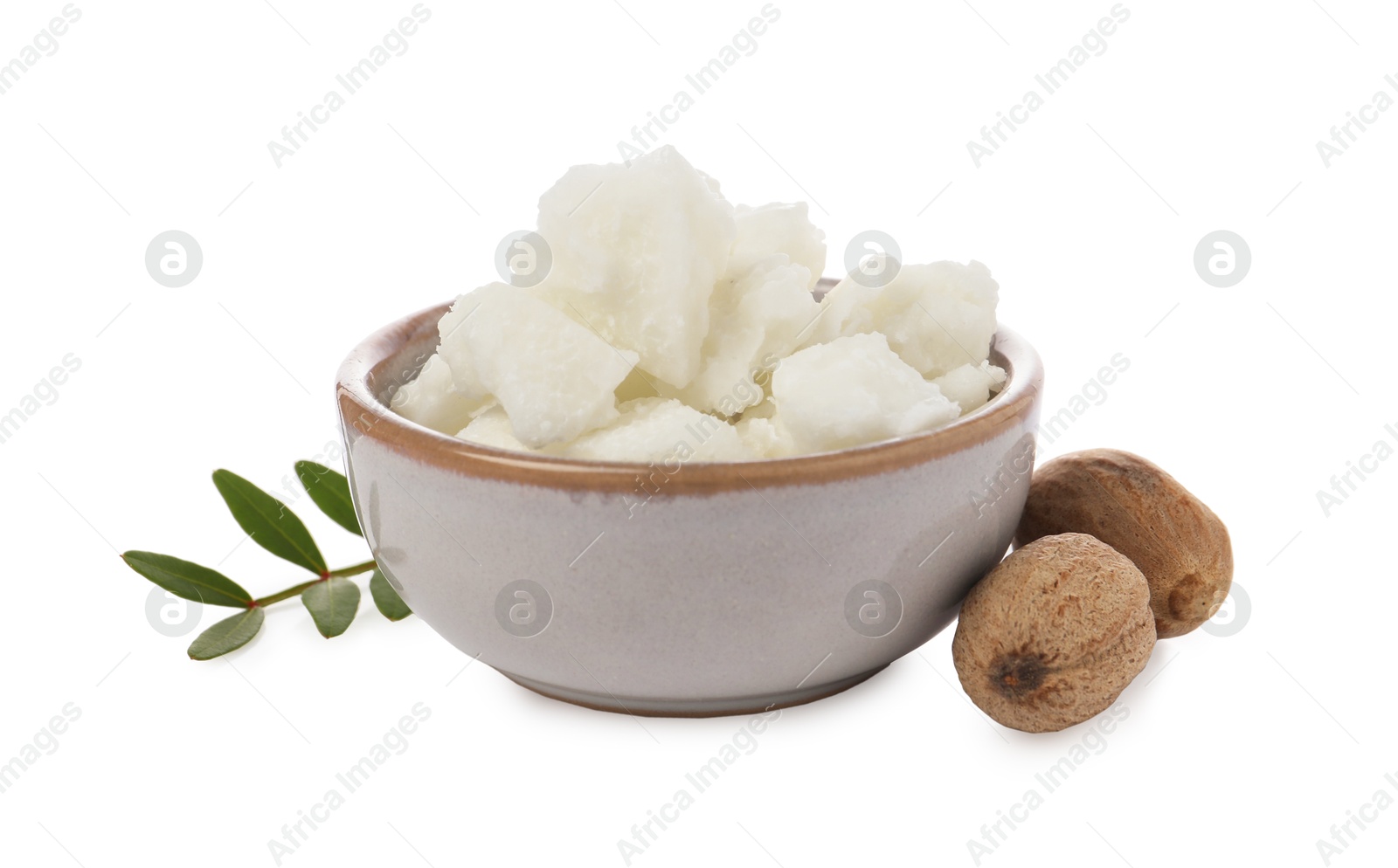 Photo of Shea butter in bowl and nuts isolated on white