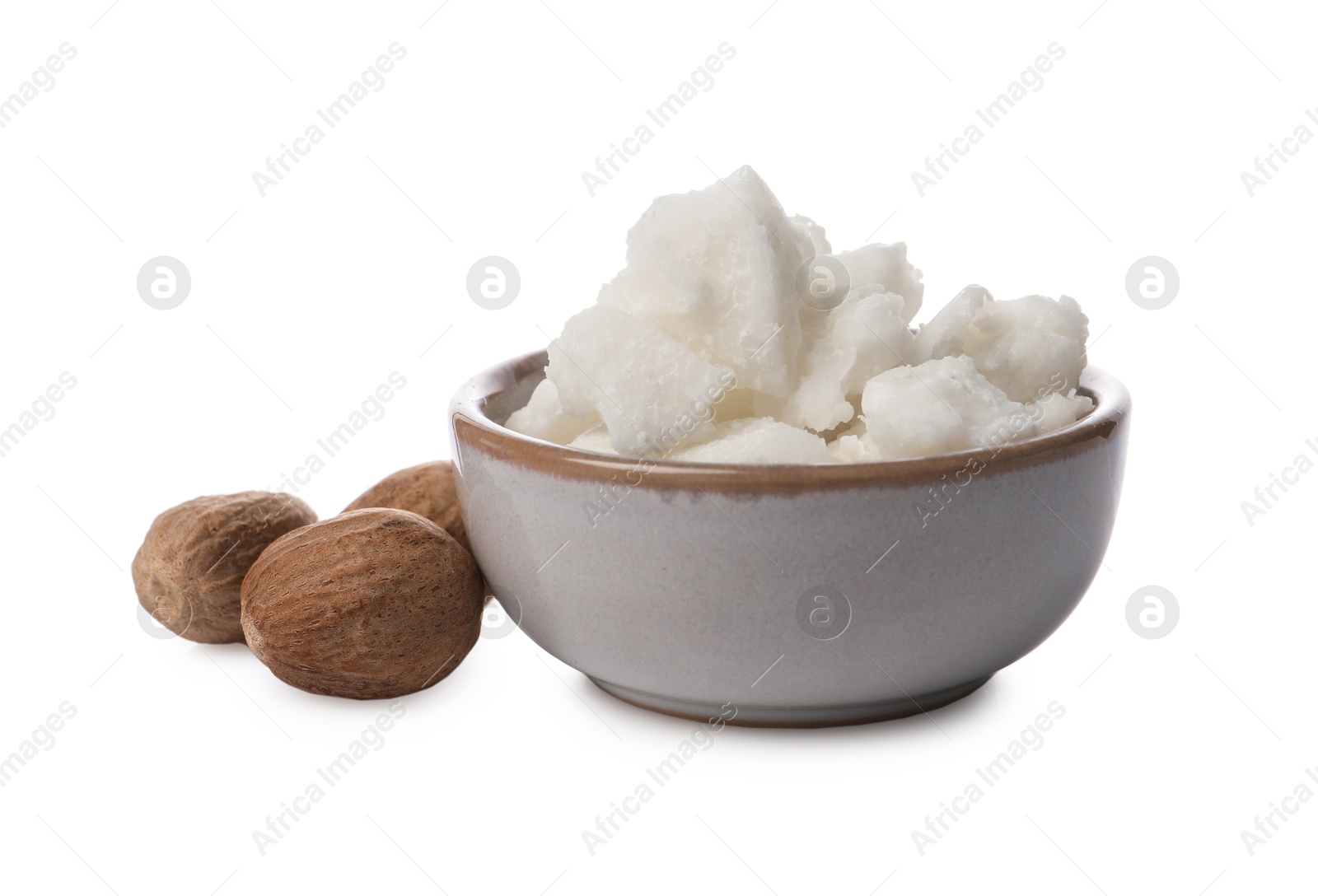 Photo of Shea butter in bowl and nuts isolated on white