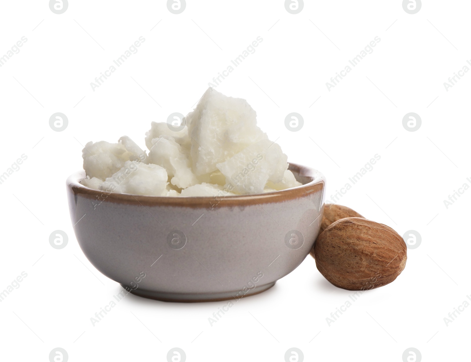 Photo of Shea butter in bowl and nuts isolated on white