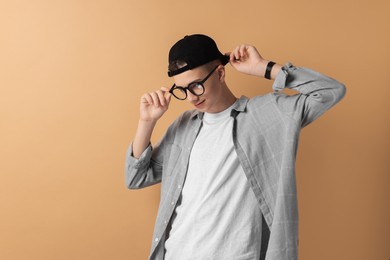 Photo of Portrait of teenage boy on dark beige background. Space for text