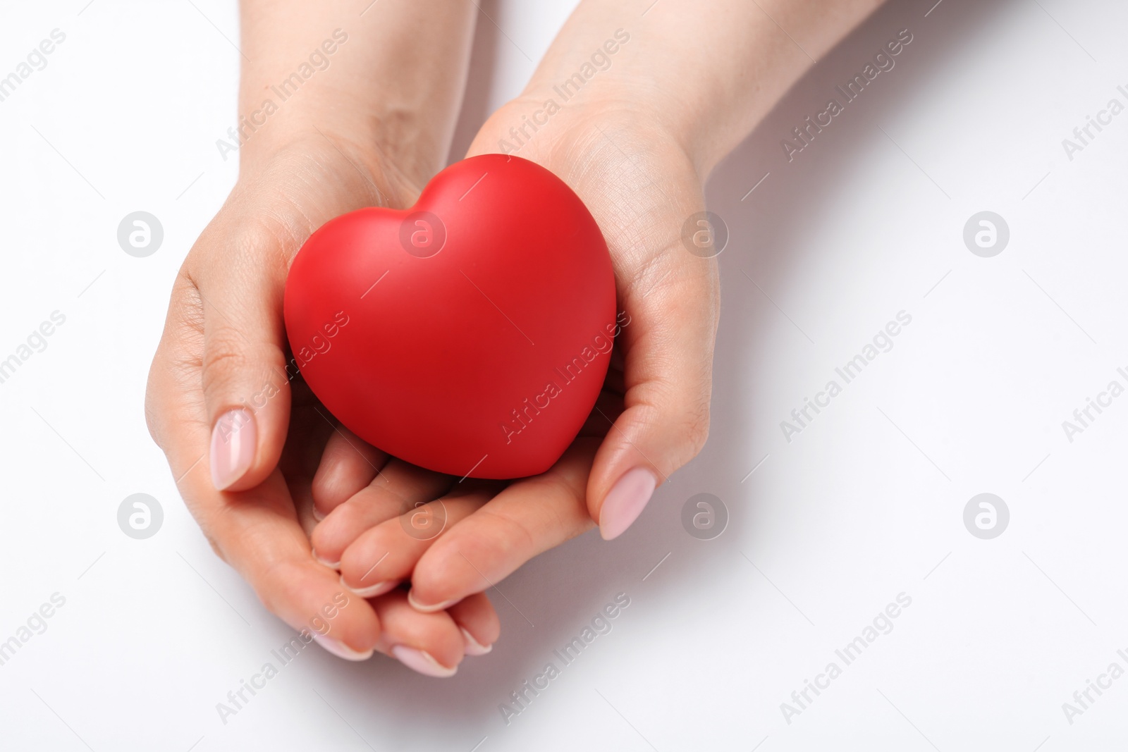 Photo of Woman with red decorative heart at white table, closeup