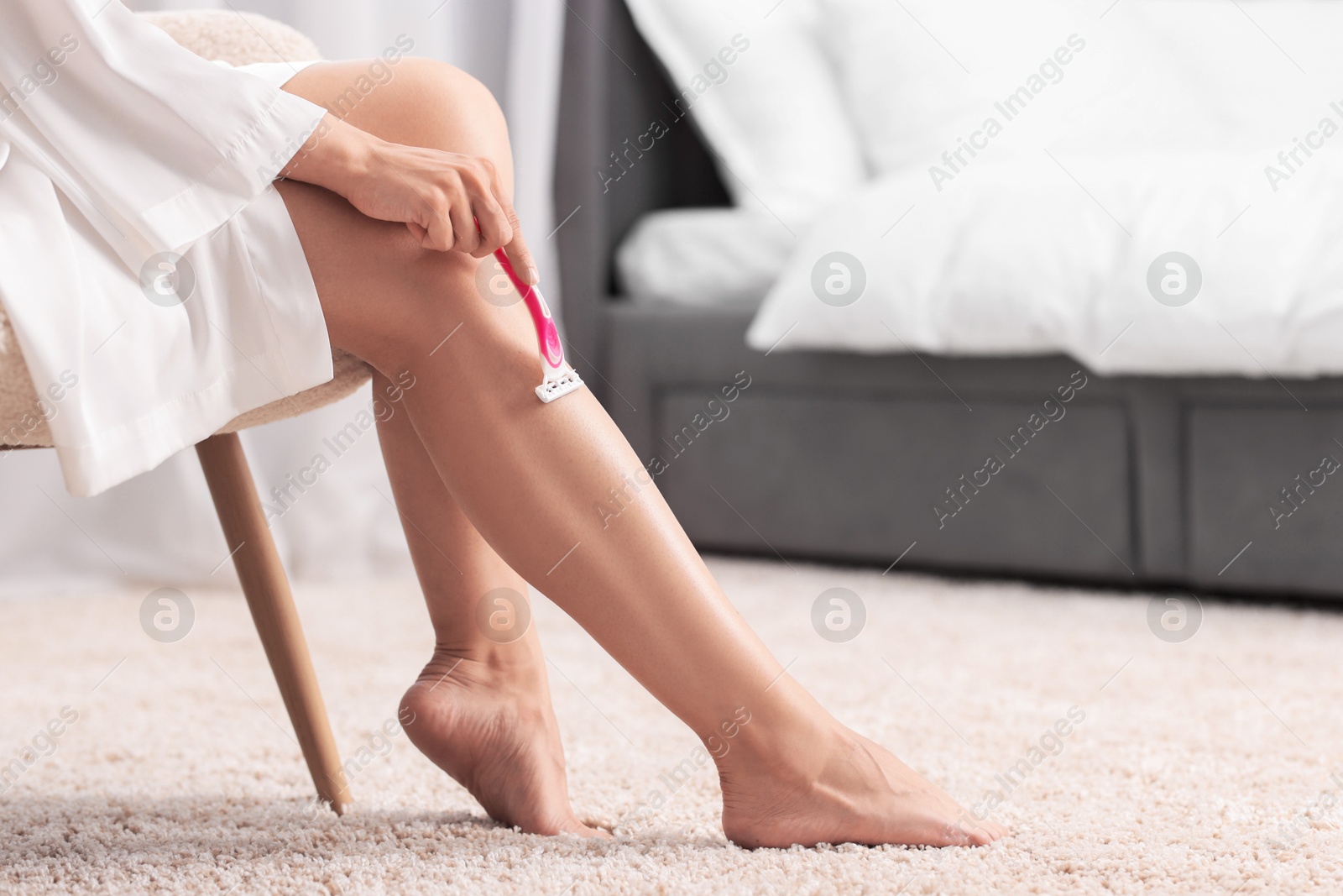 Photo of Woman shaving leg indoors, closeup. Space for text