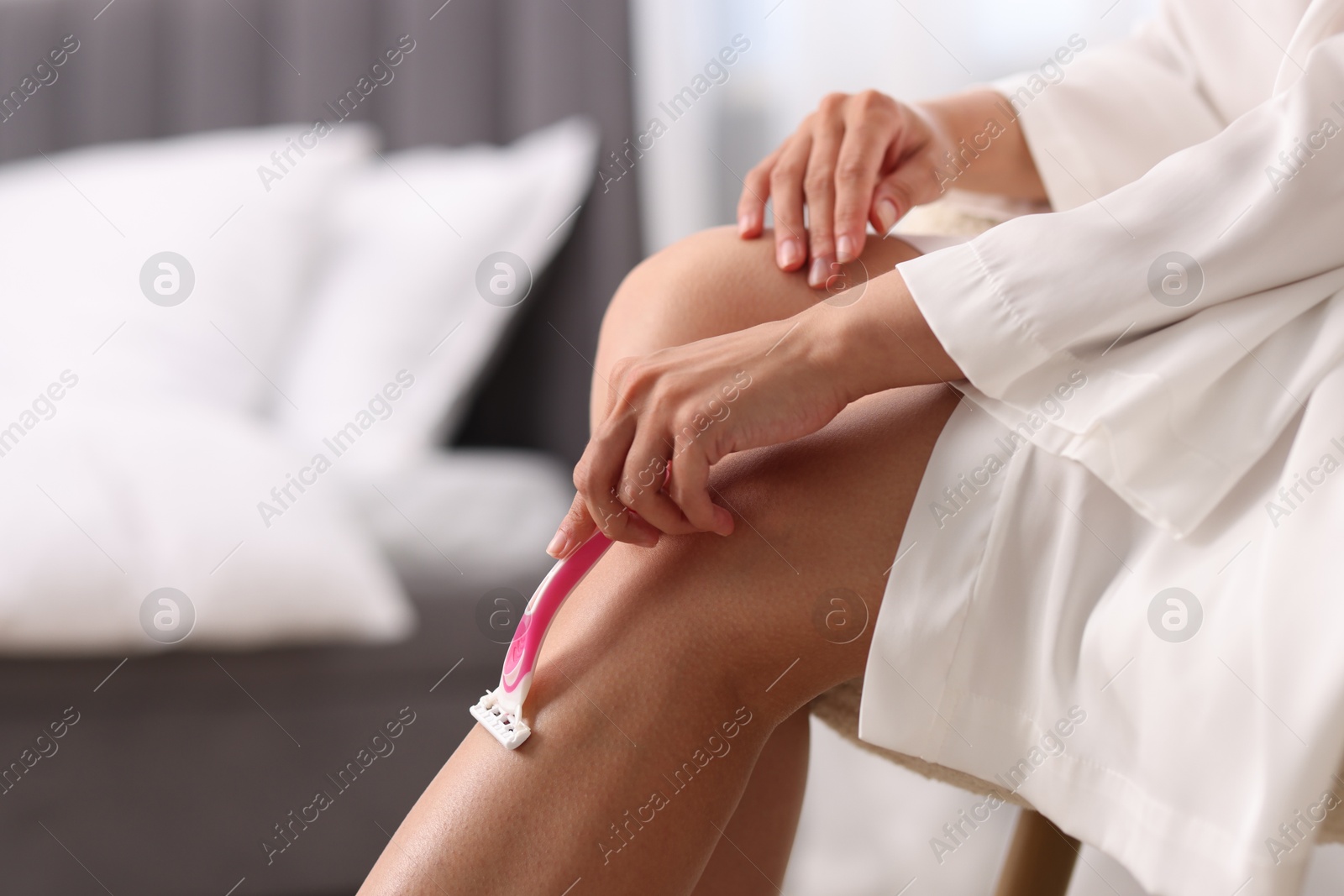 Photo of Woman shaving leg indoors, closeup. Space for text