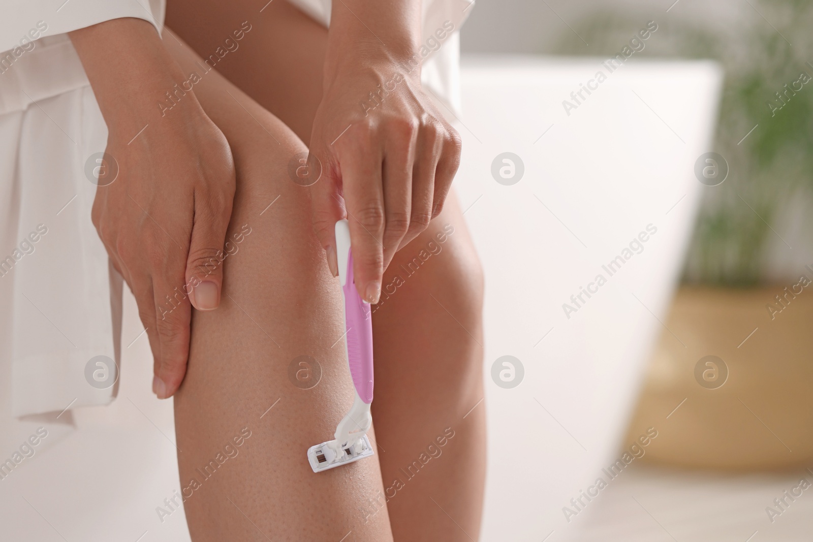 Photo of Woman shaving leg at home, closeup. Space for text