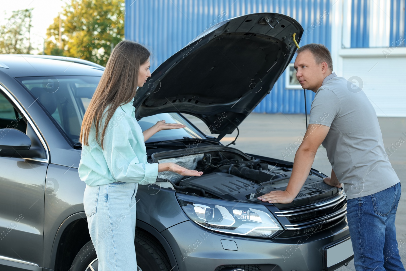 Photo of Man and woman near broken car outdoors