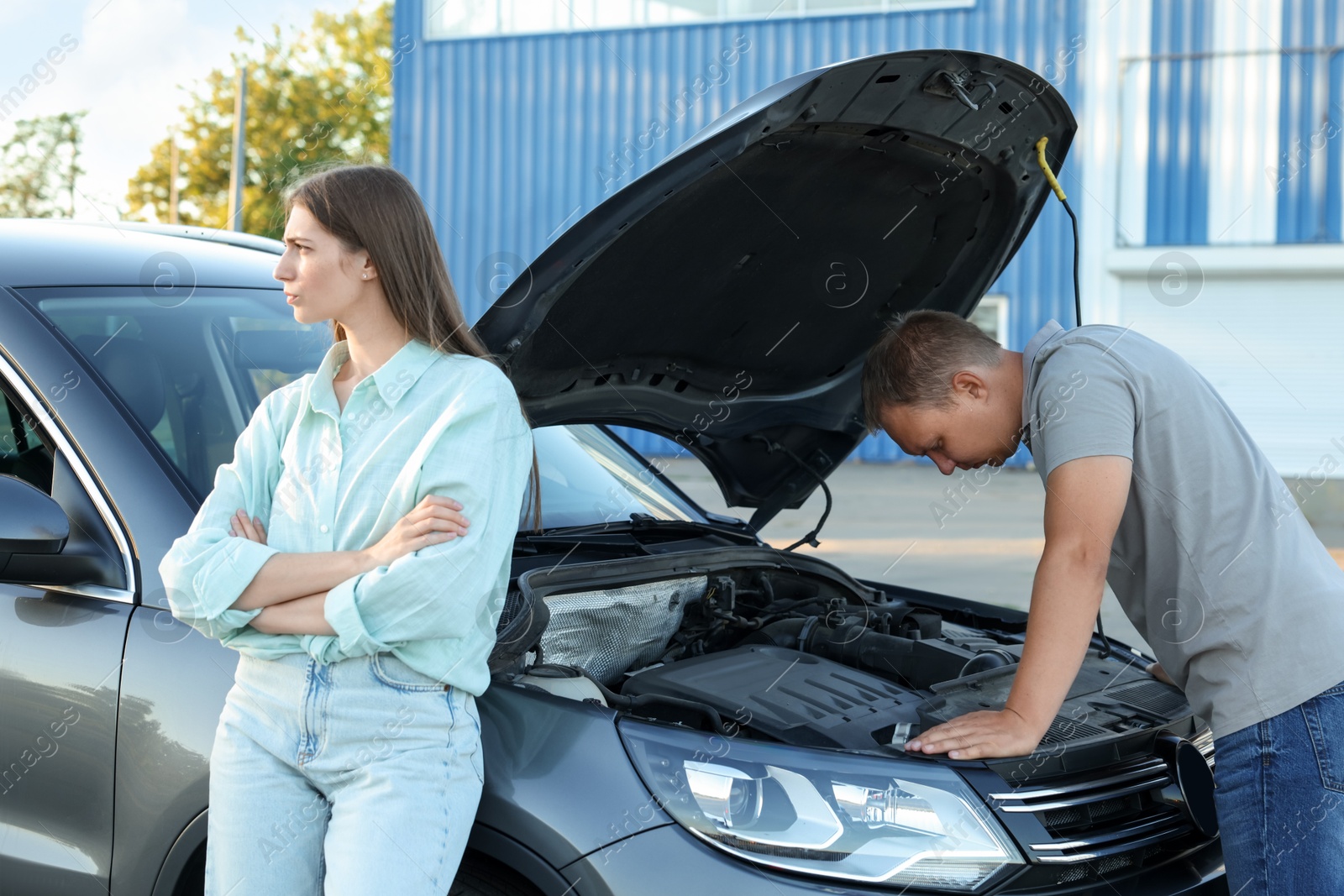 Photo of Man and woman near broken car outdoors