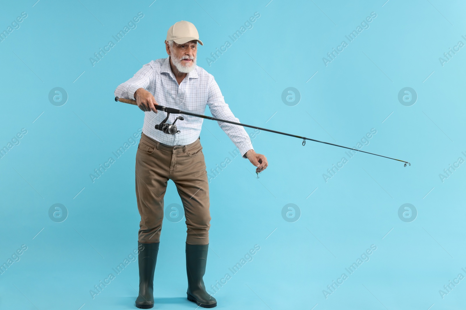 Photo of Fisherman with rod on light blue background